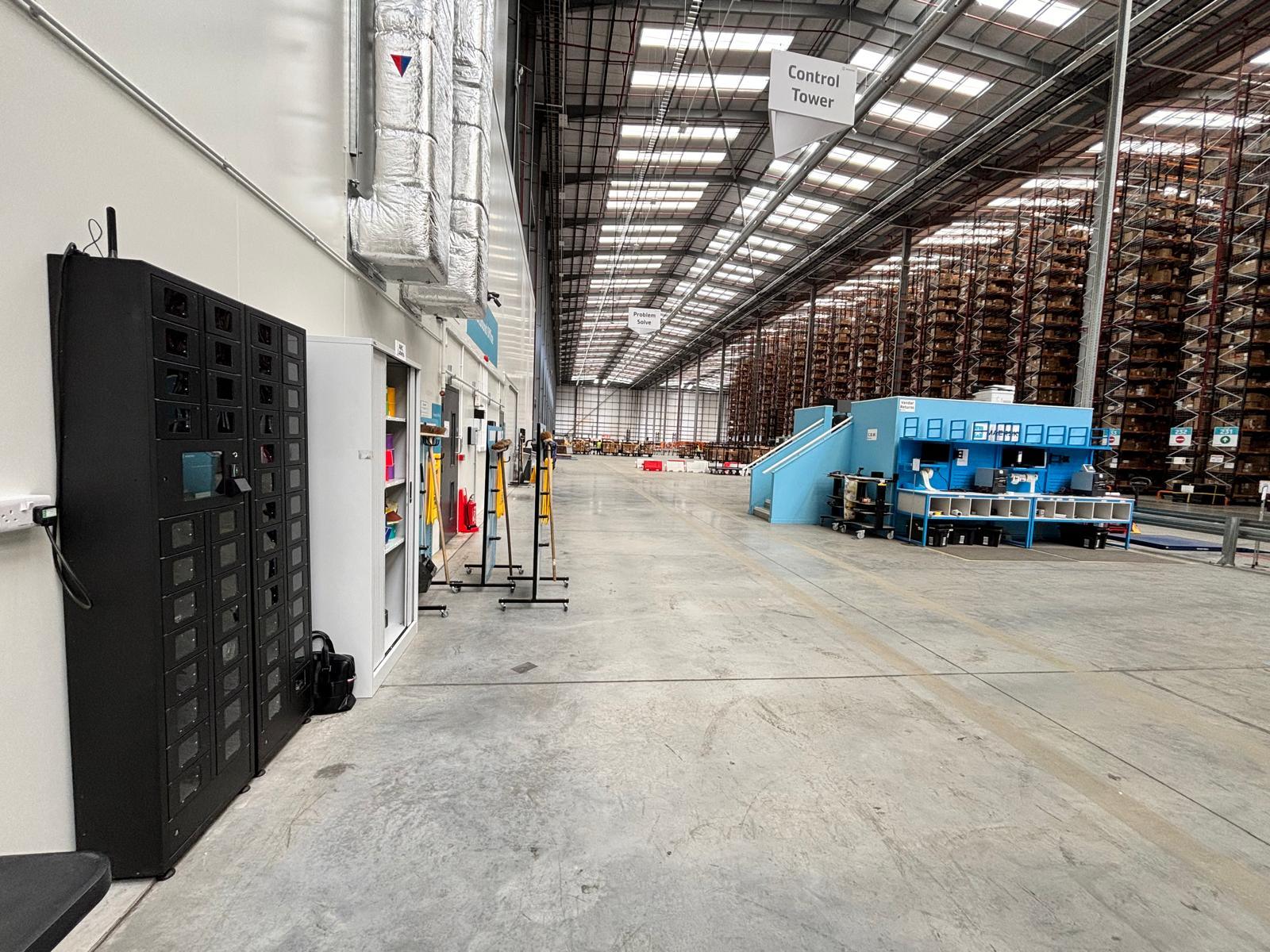 iLockerz scanner management system at Maersk, featuring clear-fronted compartments and a central touchscreen for secure checkout and automated tracking of handheld scanners.